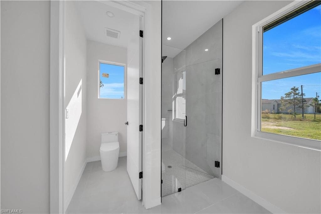Full bath featuring a shower stall, light tile patterned floors, and recessed lighting