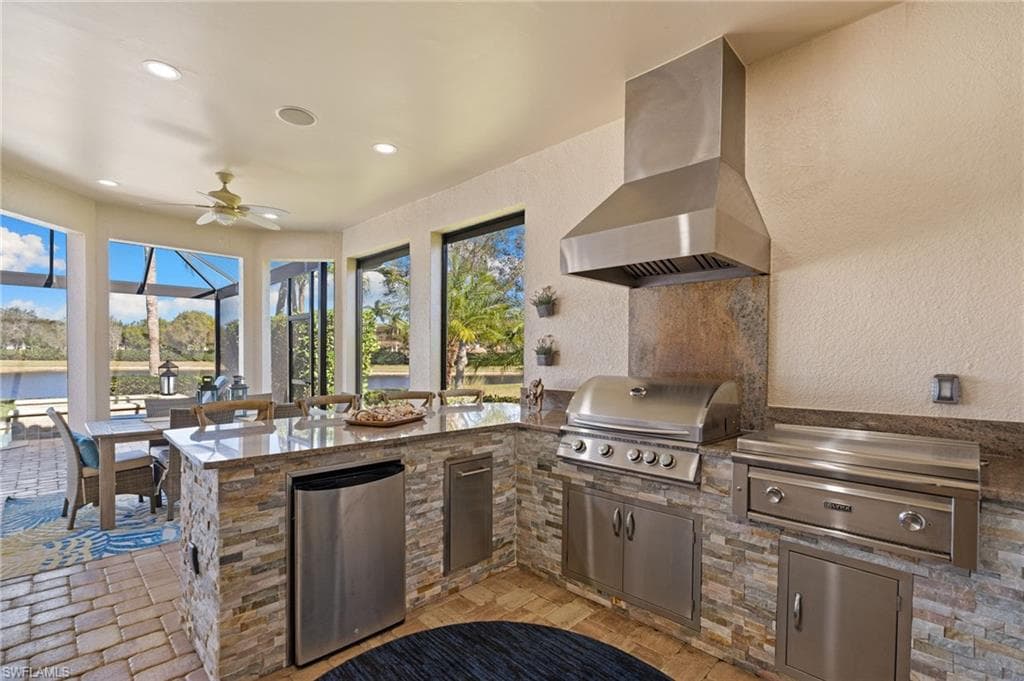 View of patio with ceiling fan, exterior kitchen, and a sunroom