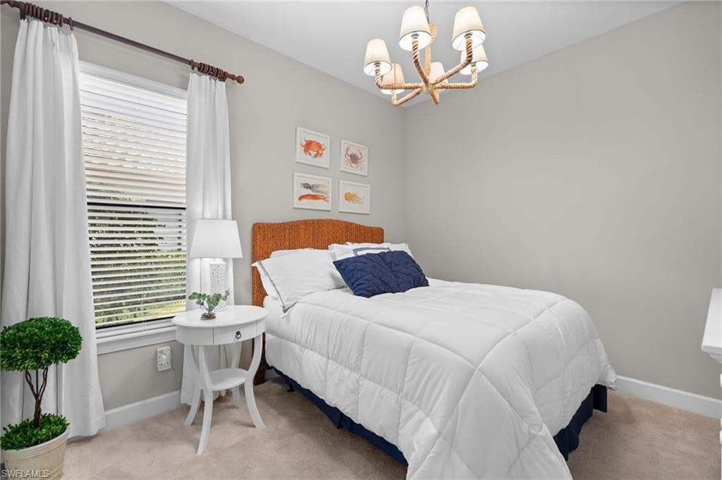 Bedroom with hanging lights and light carpet