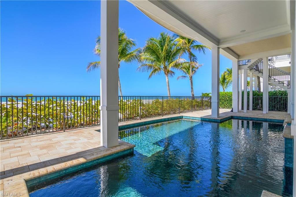 View of pool featuring patio surround and a water view