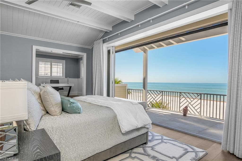 Bedroom featuring view of water and beach, access to outside, wood finished floors, vaulted ceiling with beams, and wood ceiling