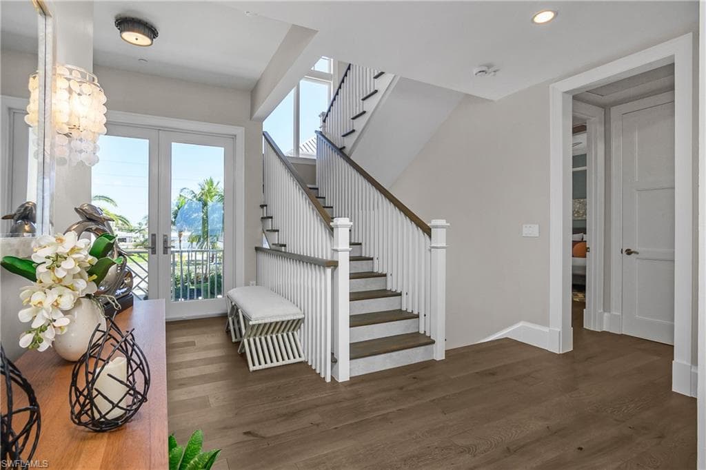 Stairway featuring french doors, wood finished floors, and recessed lighting