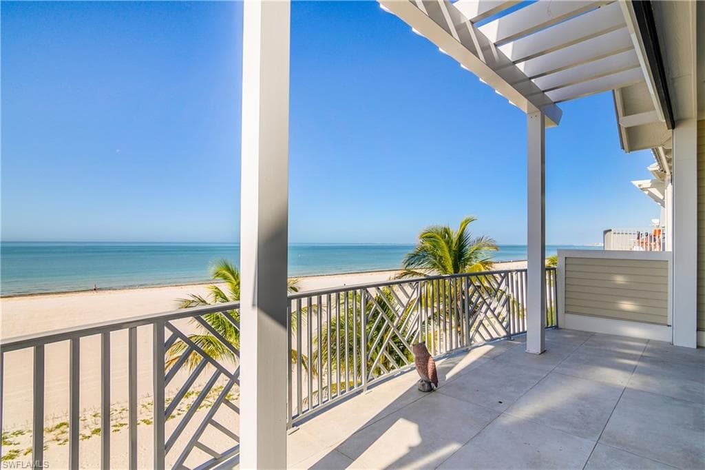 View of patio / terrace featuring view of water and beach