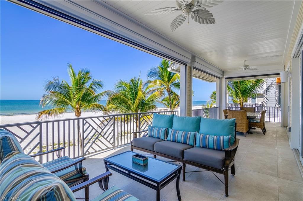 View of patio / terrace featuring a ceiling fan, view of water and beach, and outdoor lounge area