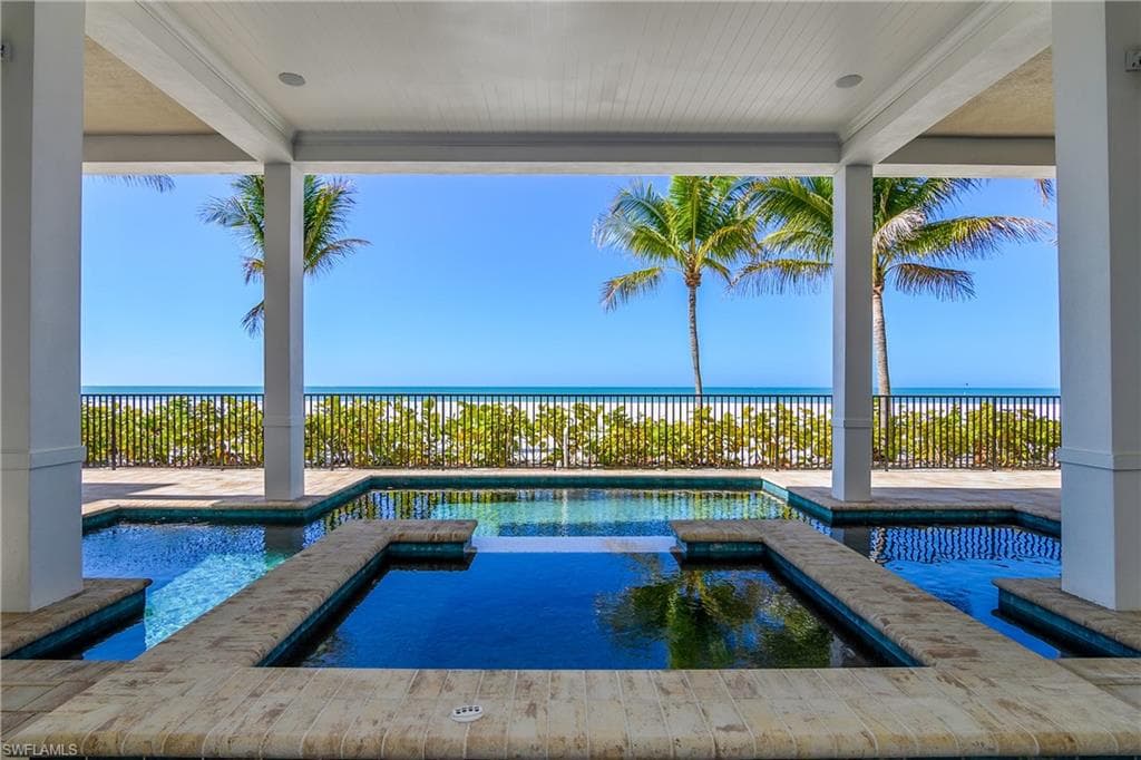 Relaxing pool / spa with a fenced backyard, a patio, and a water view