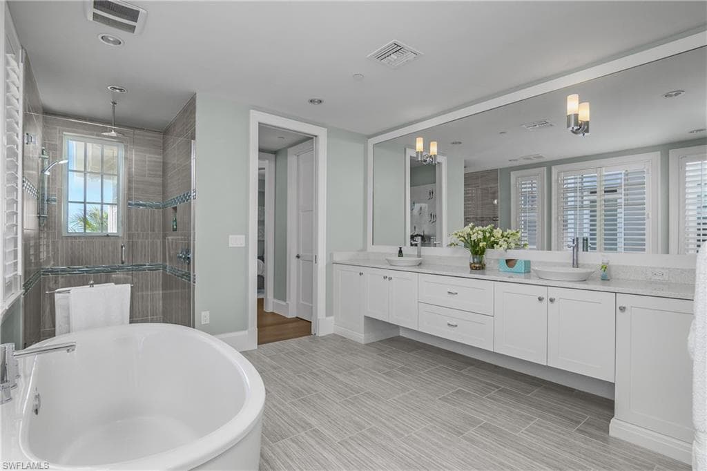 Bathroom with a shower stall, a freestanding tub, double vanity, and wood tiled floors