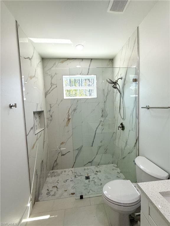 Master bathroom featuring vanity and a marble finish shower