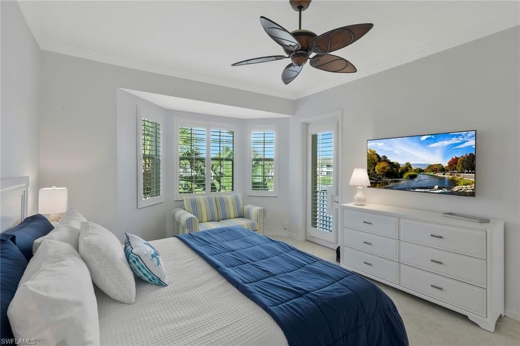 Spacious primary suite featuring high ceilings, a comfortable seating area, peaceful water views, and private access to the screened lanai.
