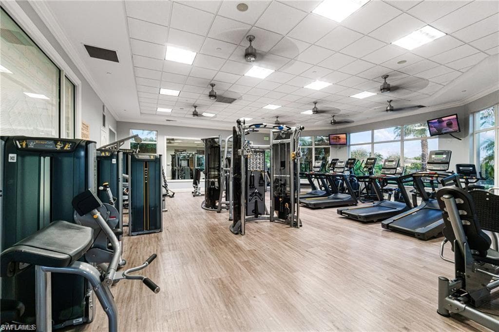 Workout area with a paneled ceiling and ornamental molding