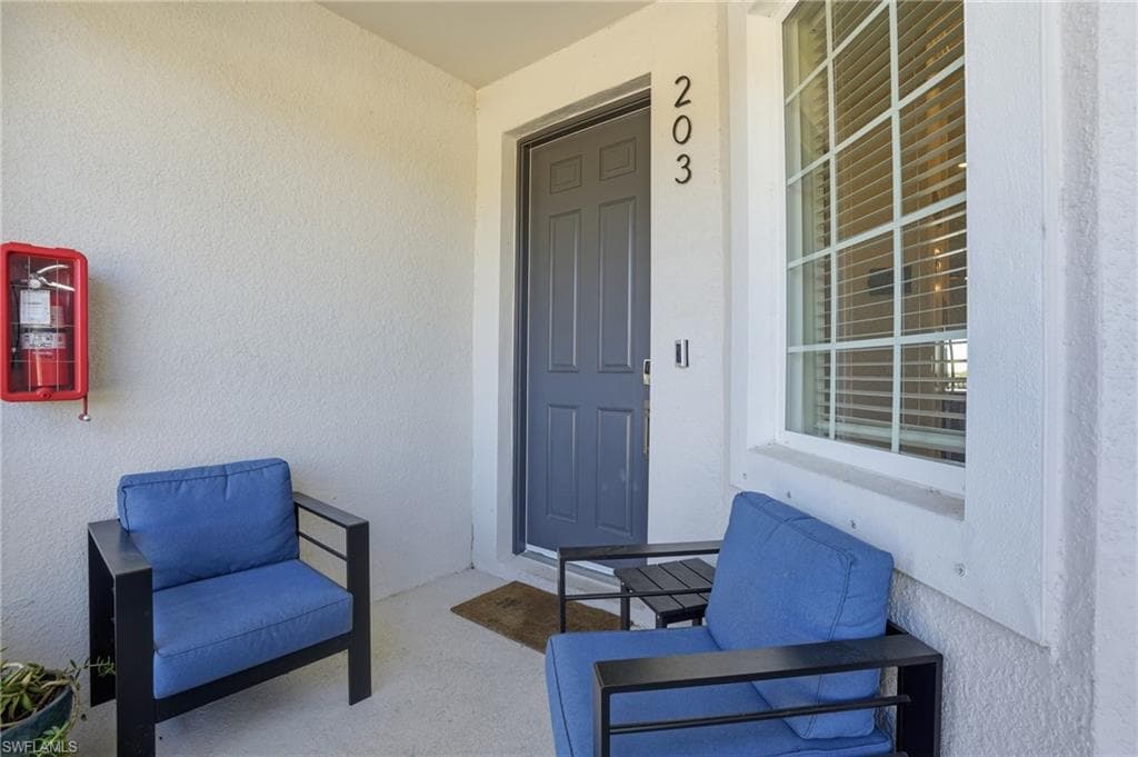 Entrance to property with stucco siding and covered porch