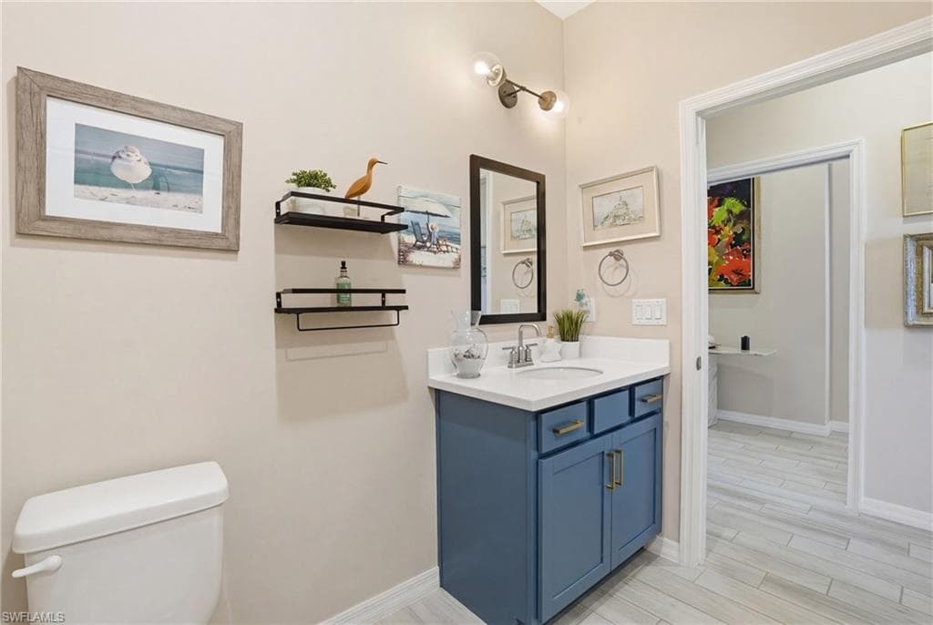 Half bath featuring vanity and wood finish floors