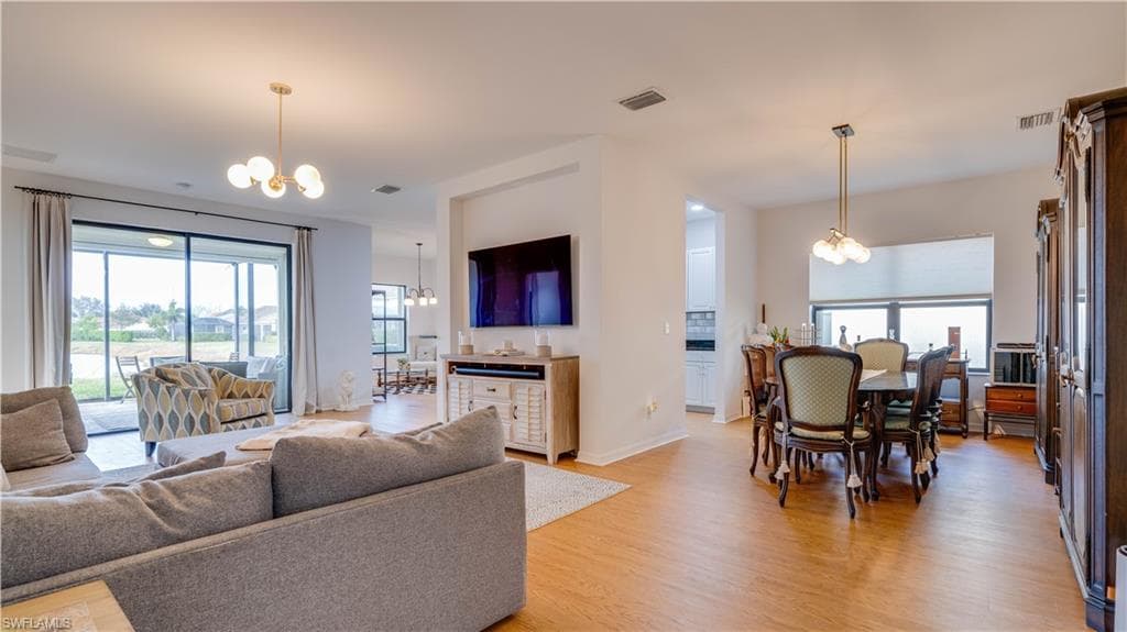 Living room featuring suspended lighting and light wood-style floors