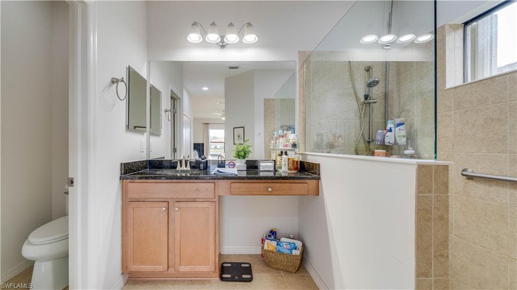 Bathroom with vanity, walk in shower, and light tile patterned floors