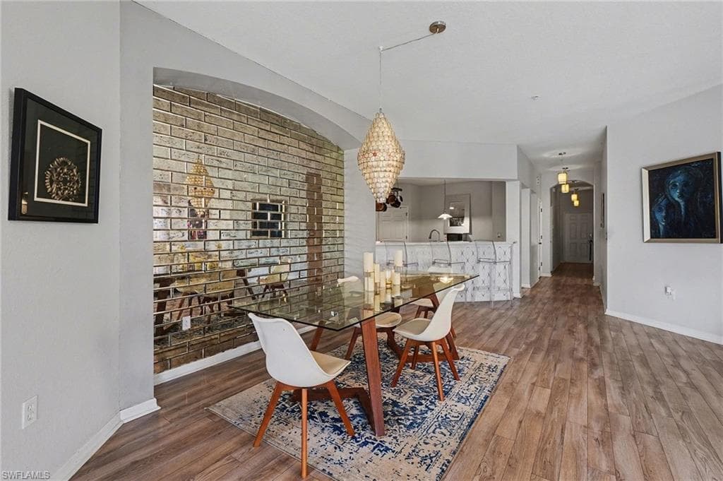 Dining room featuring dark wood-style flooring and a chandelier