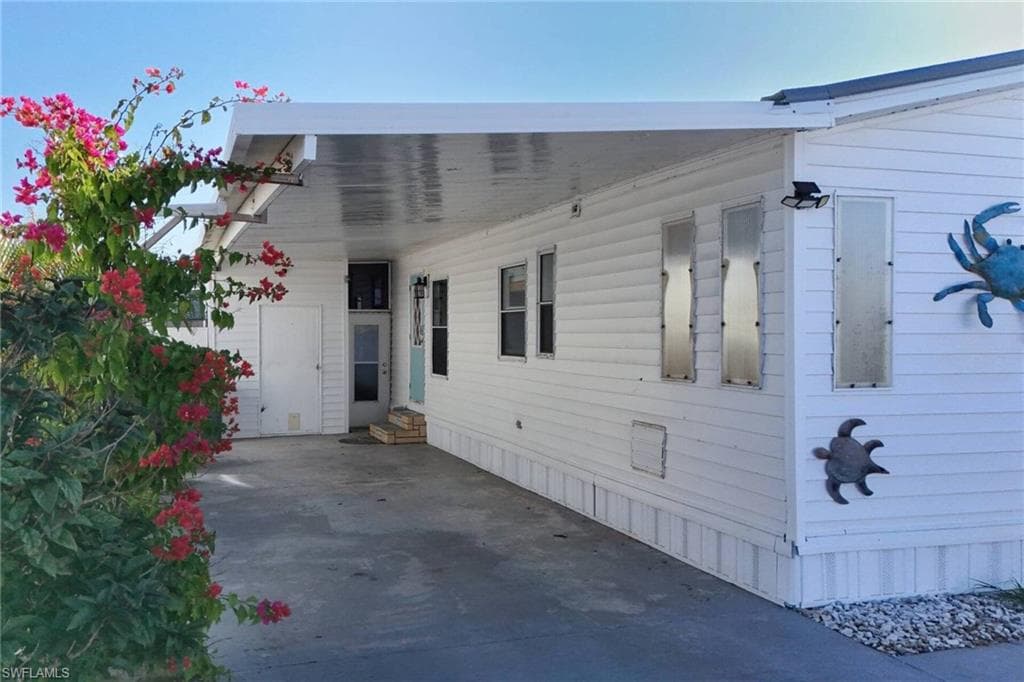 View of side of home with a carport and entry steps