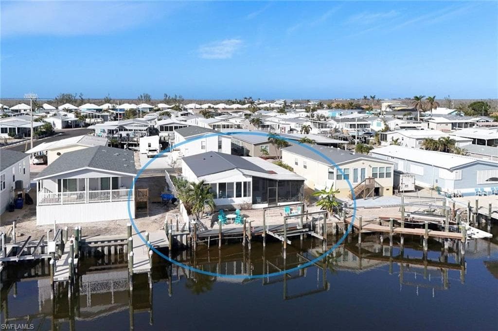 Dock featuring boat lift, a residential view, and a water view