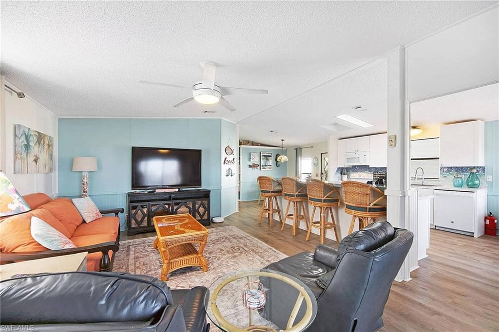 Living room with light wood finished floors and ceiling fan