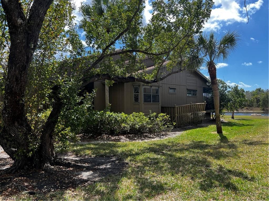 View of side of property with a lawn and a water view