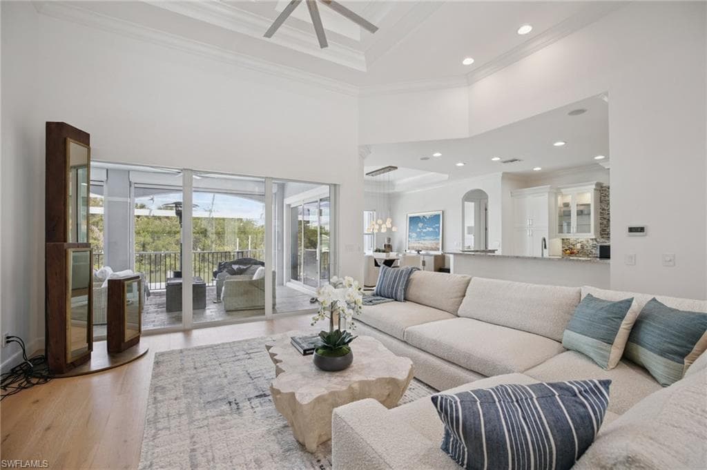 Living area featuring a coffered ceiling, ornamental molding, recessed lighting, wood flooring, and a ceiling fan