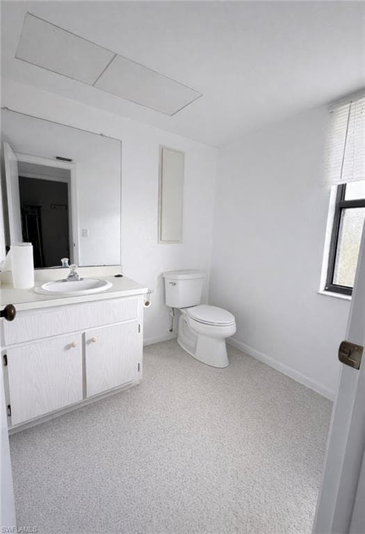 Half bathroom with vanity and light carpet