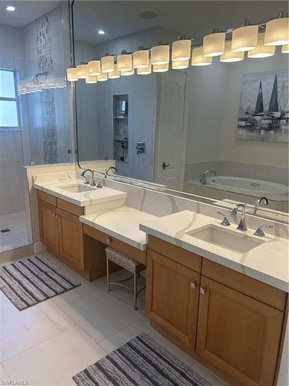 Primary bath featuring double vanity, a tile shower, light tile patterned floors
