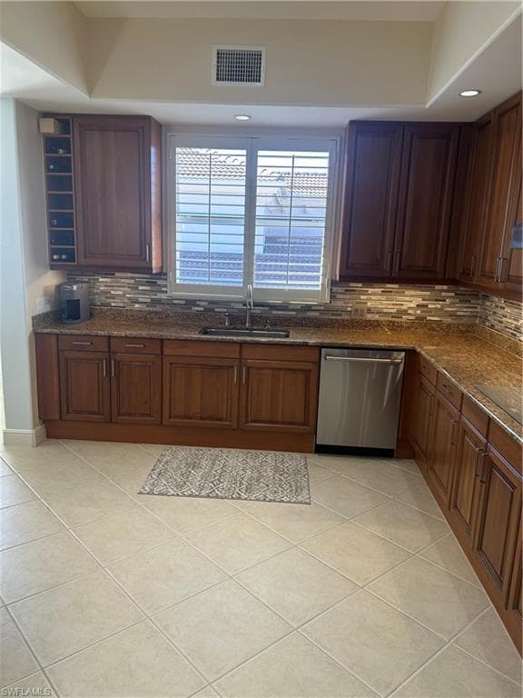 Kitchen featuring dishwasher, light tile patterned floors, dark stone counters, tasteful backsplash, and recessed lighting