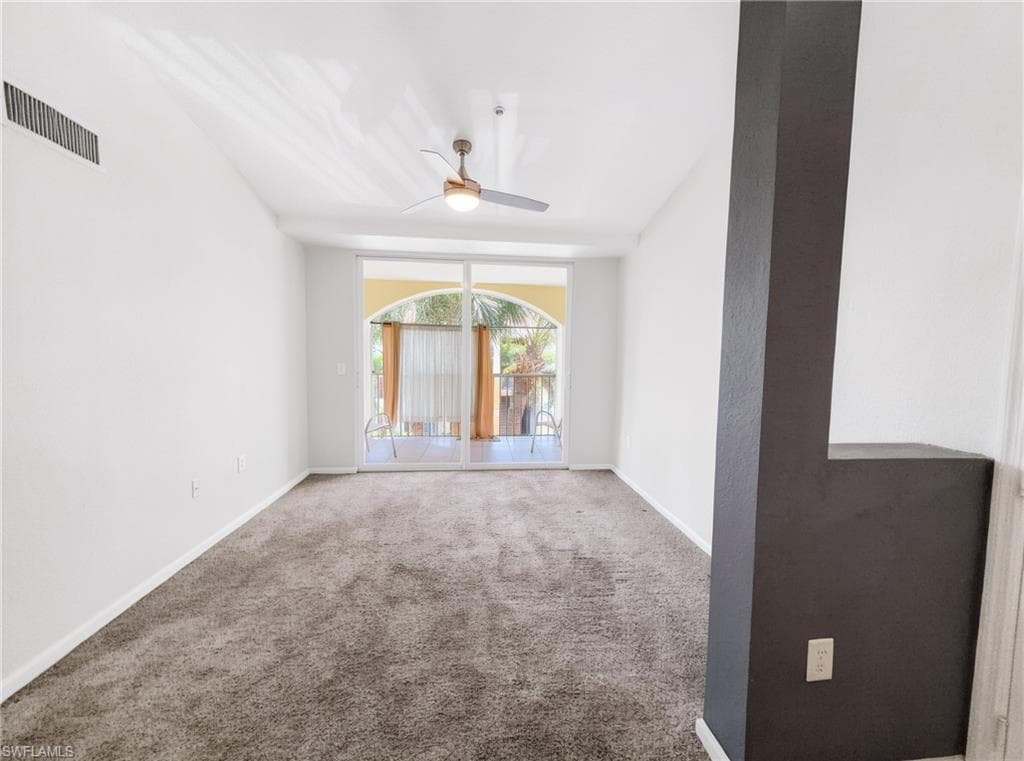 Carpeted room with vaulted ceilings and a ceiling fan