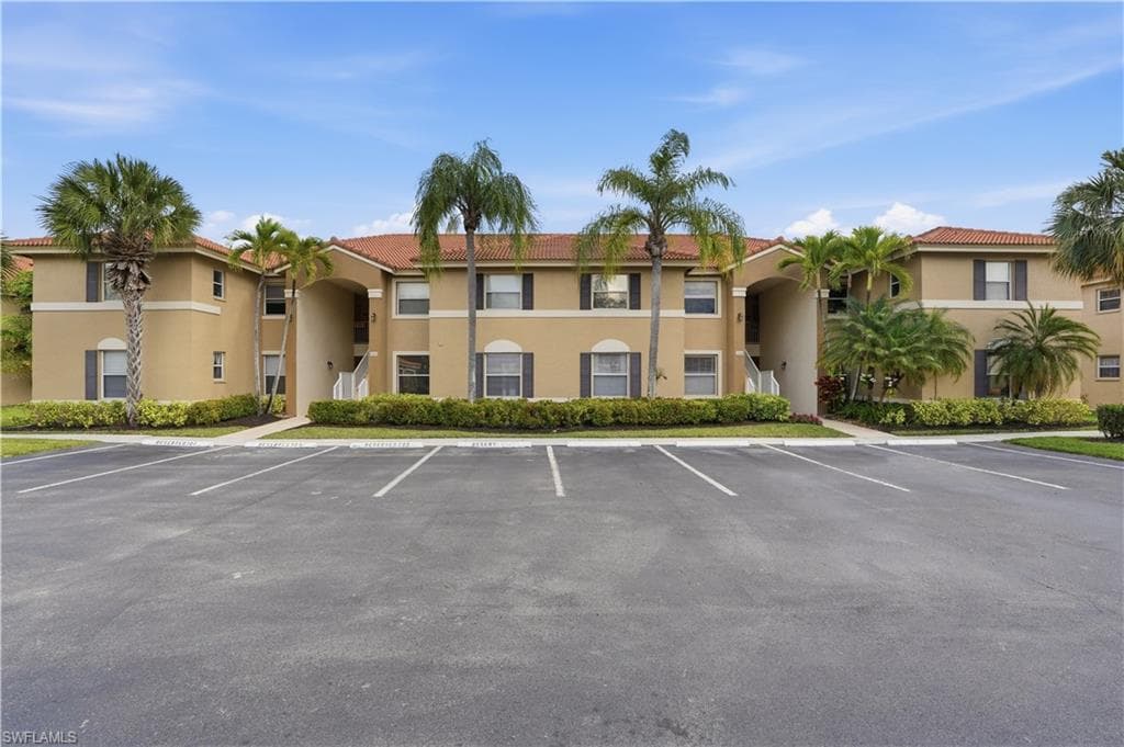 View of apartment building / complex with uncovered parking