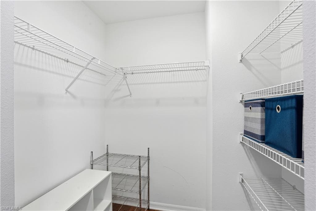 Walk in closet with wood finished floors