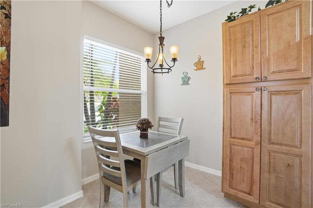 Dining space with suspended lighting and light tile patterned floors