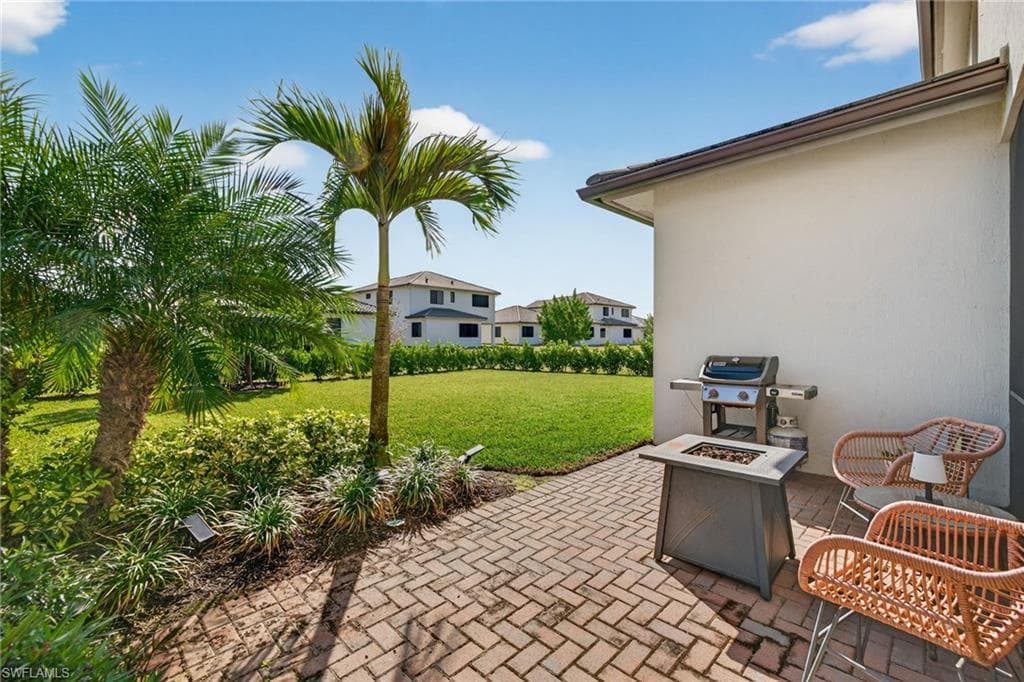 View of patio with a fire pit and a grill