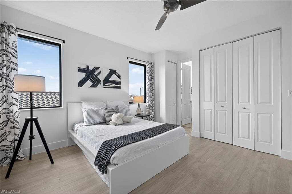 Bedroom featuring light wood-style flooring, a ceiling fan, and a closet