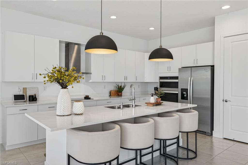 Kitchen featuring stainless steel appliances, white cabinets, and light tile patterned floors