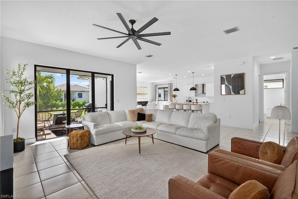 Living room with a ceiling fan and light tile patterned floors