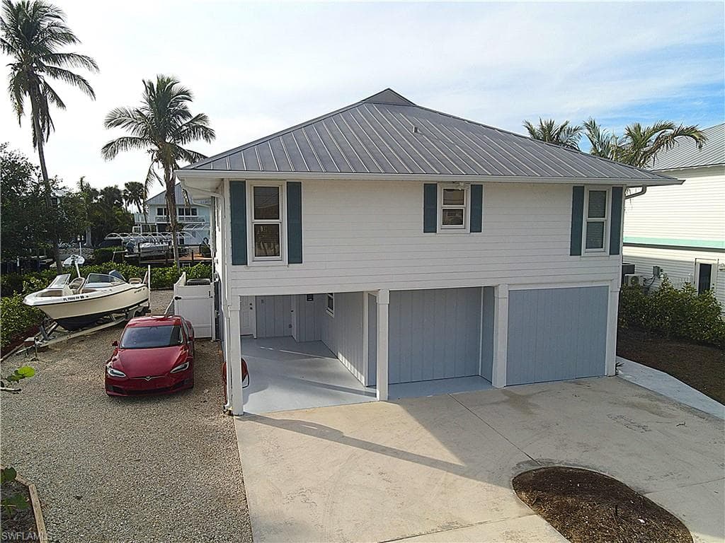 View of front facade with a metal roof, concrete driveway, and a garage