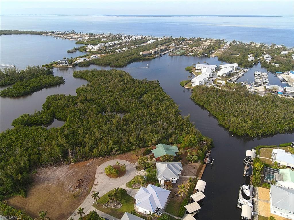 Aerial view of property and surrounding area with a nearby body of water