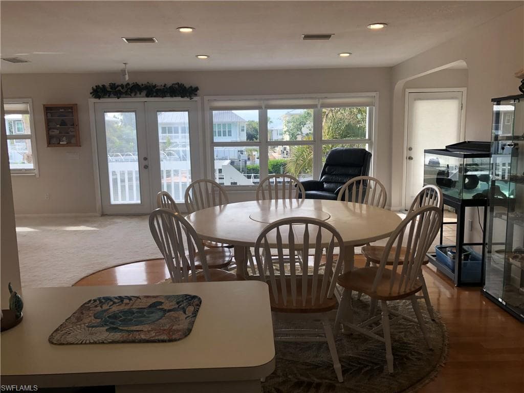 Dining space featuring french doors, plenty of natural light, recessed lighting, and wood finished floors