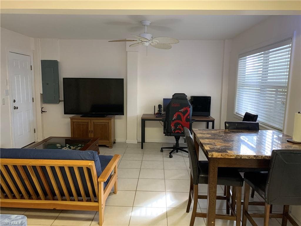 Office space featuring electric panel, light tile patterned flooring, and a ceiling fan