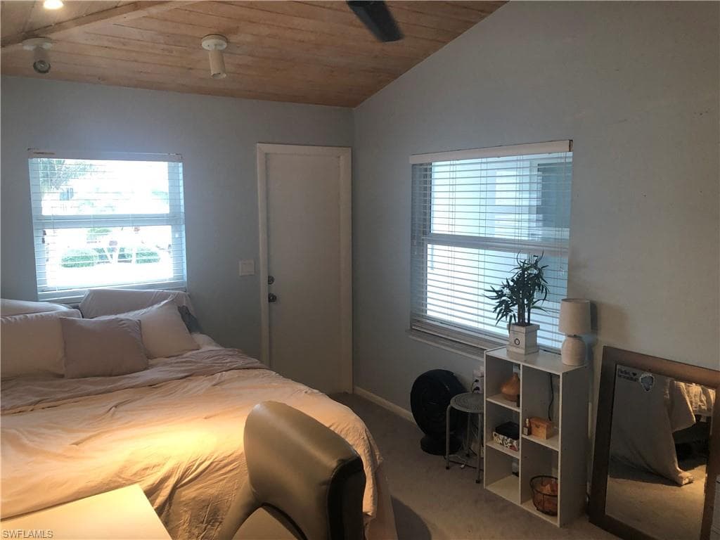 Carpeted bedroom with vaulted ceiling and wood ceiling