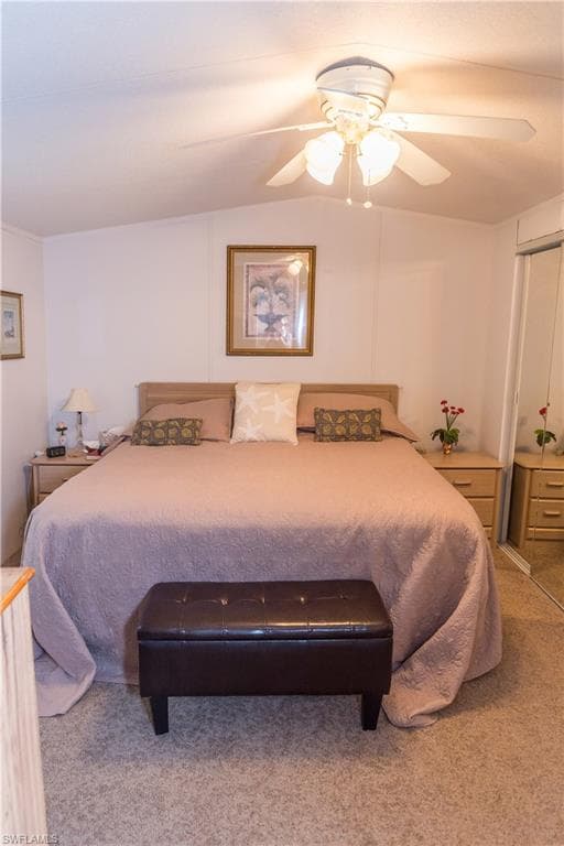 Carpeted bedroom featuring ceiling fan and a closet