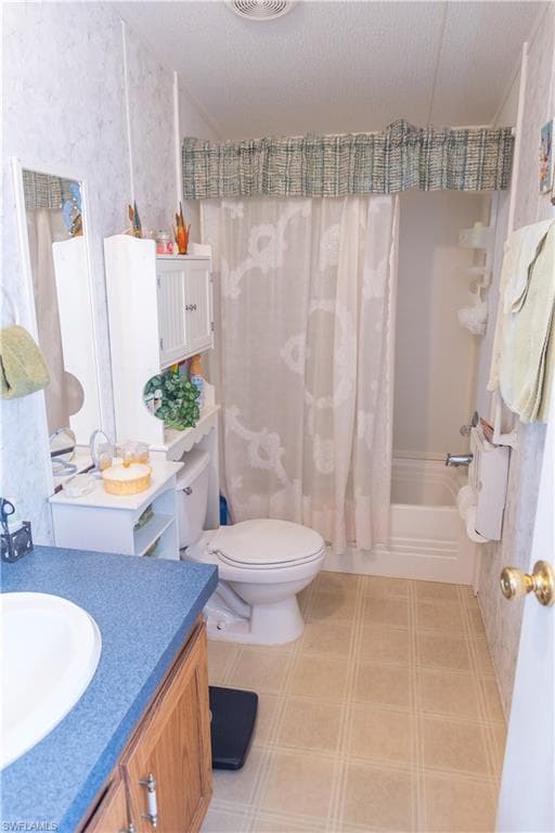 Full bath with vanity, shower / bath combo, and a textured ceiling