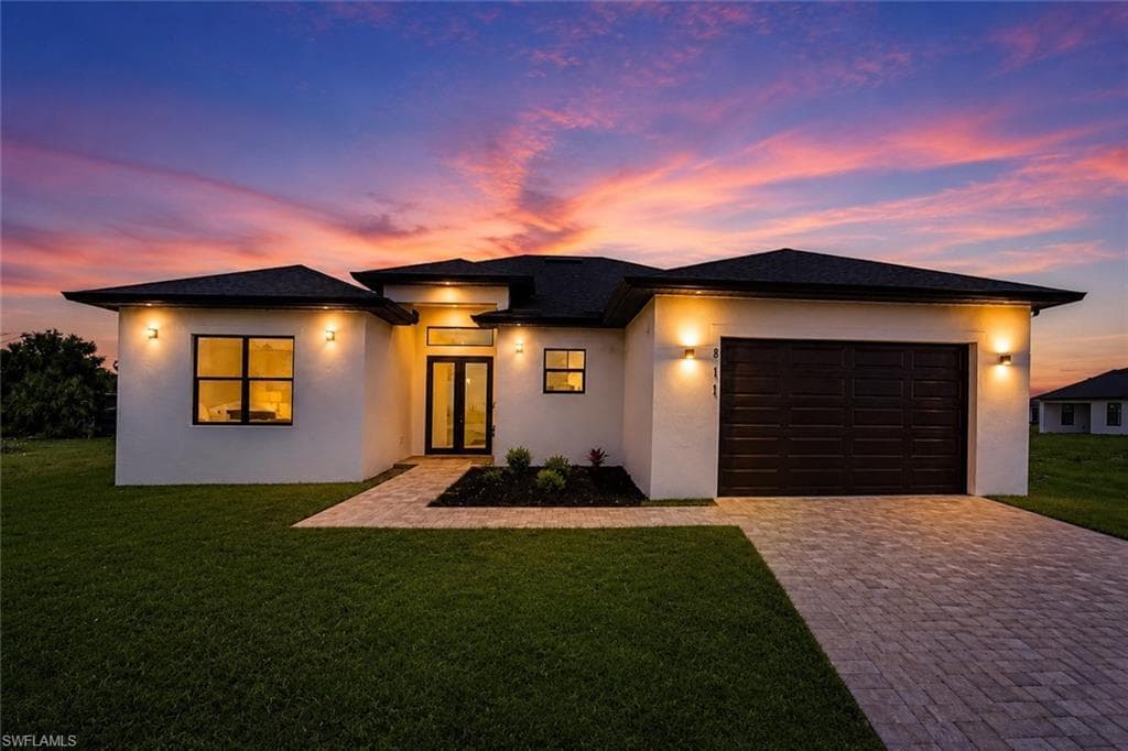 Contemporary white stucco exterior with black framed windows and a dark shingle roof