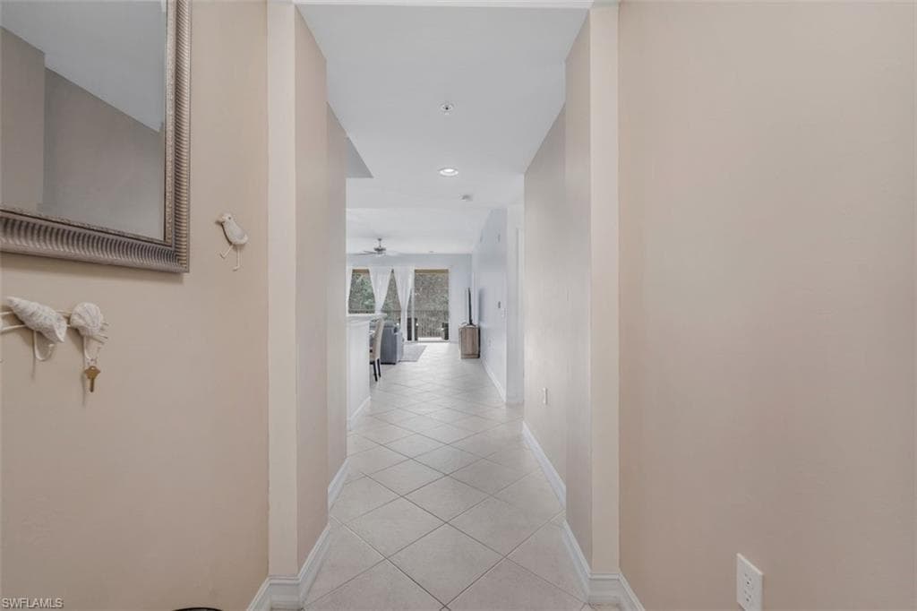 Corridor with light tile patterned floors and recessed lighting