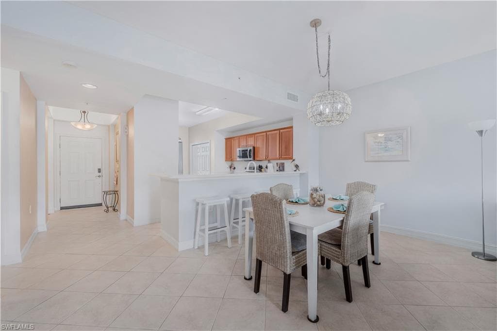 Dining room with light tile patterned floors and hanging lights