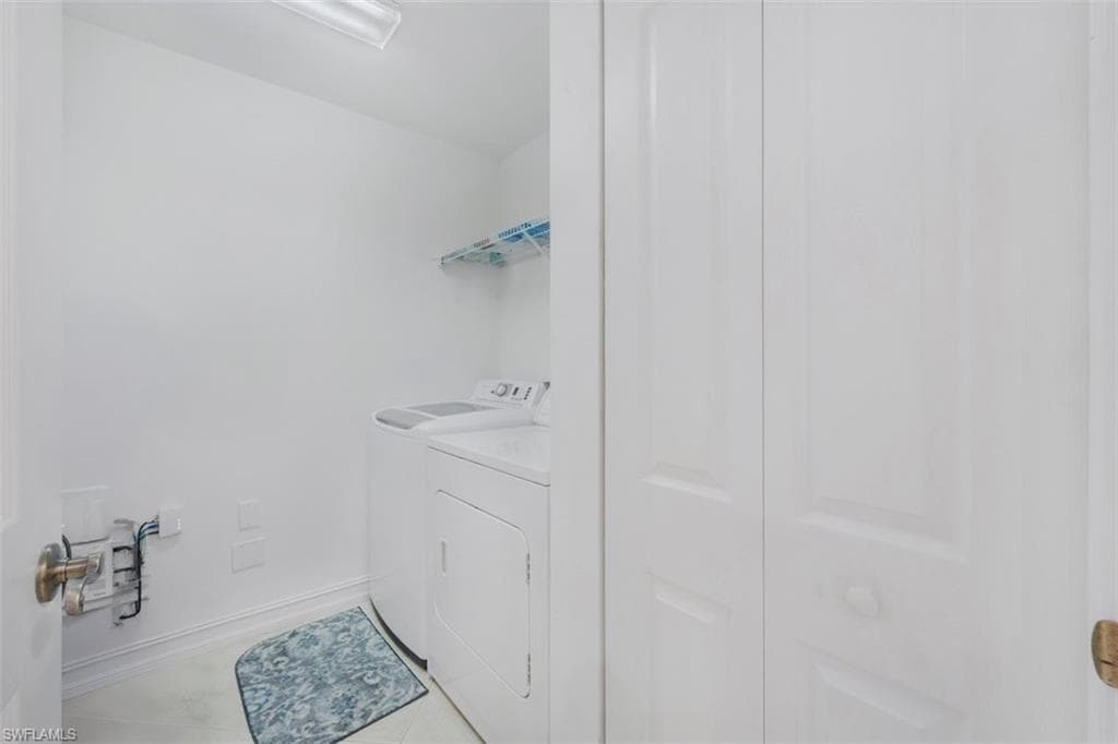 Laundry room with washer and dryer and tile patterned flooring