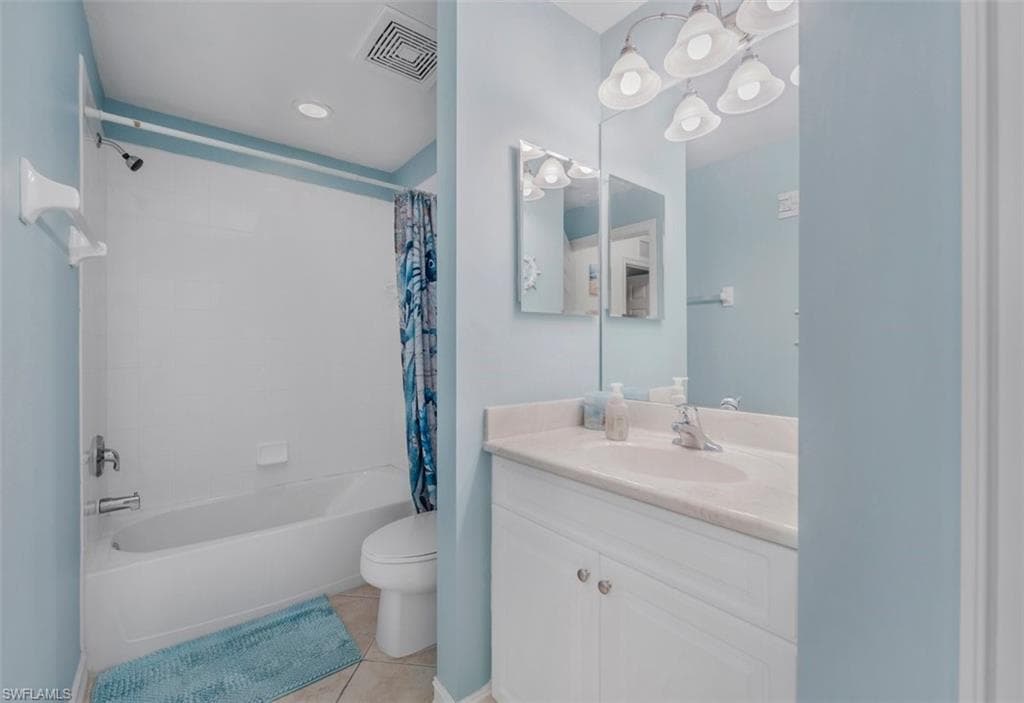 Bathroom featuring a single vanity with a white countertop, two-door white cabinet, wall-mounted mirror, and a combined shower and tub with white surround