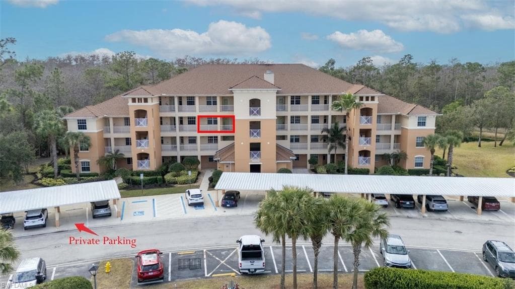 View of apartment building / complex featuring uncovered parking