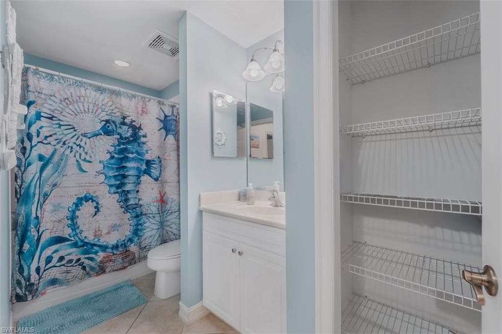 Bathroom featuring a single vanity, undermount sink, built-in medicine cabinet, and overhead light fixture