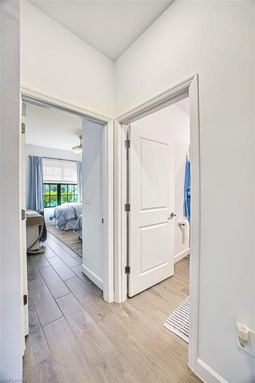 Hall with light wood finished floors and baseboards