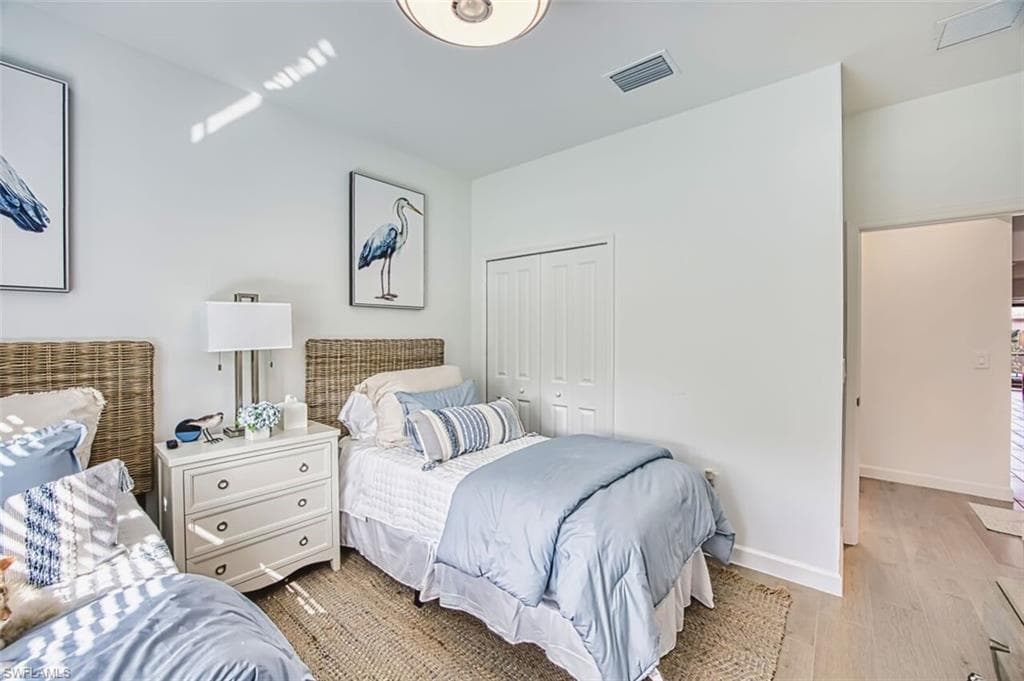 Bedroom with wood finished floors and a closet
